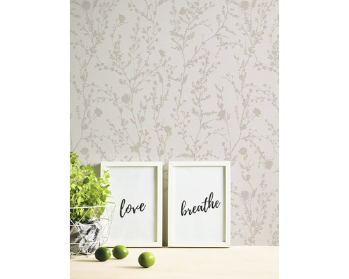 Scene met bloemenbehang, twee fotolijsten, een plant en limoenen