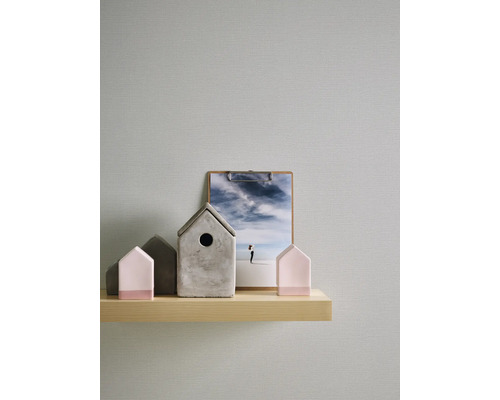 Decoratieve huizen van beton en hout op een plank met een foto op de achtergrond.