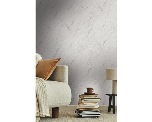 Woonkamer met patroonbehang, bank, boeken, tafellamp en vloerkleed voor een gezellige sfeer