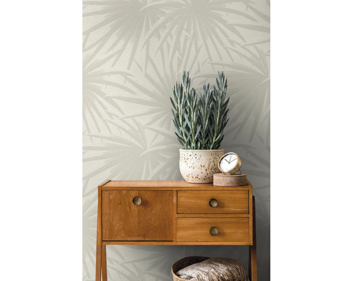Kamer met behang met print, dressoir, potplant en decoratieve objecten.