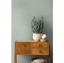 Decoratieve scène met dressoir, plant en klok tegen een wand
