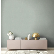 Woonkamer met patroonbehang, dressoir en decoraties.