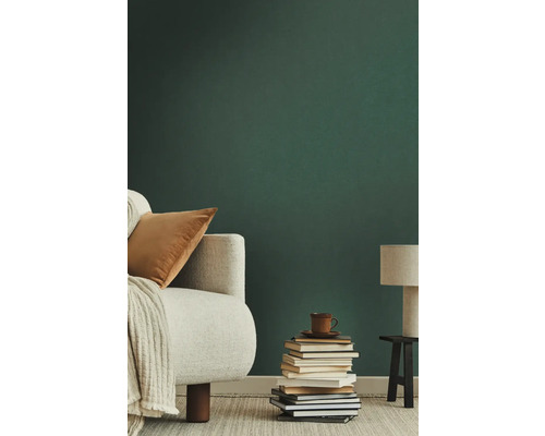 Woonkamer met fauteuil, stapel boeken en lamp