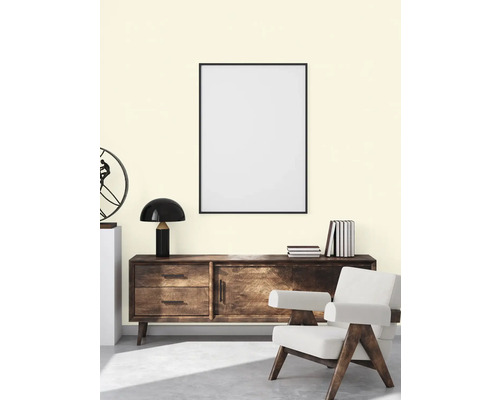Woonkamer met dressoir, lamp, fauteuil en poster met lijst