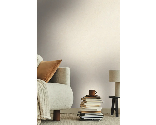 Woonkamer met bank, stapel boeken en behang met structuur