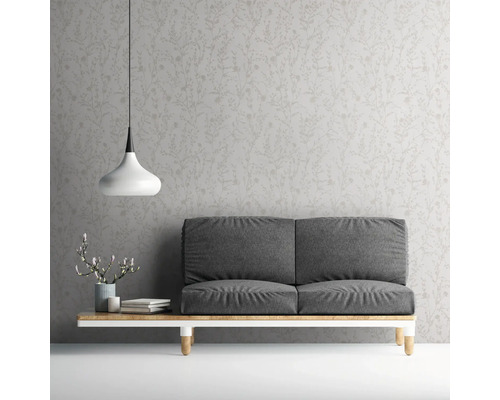 Woonkamer met grijze bank, lamp en behang met motief