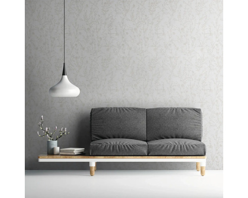 Woonkamer met grijze bank, lamp en behang met motief