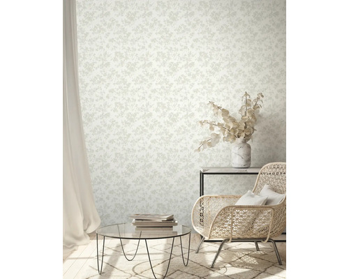 Woonkamer met patroonbehang, fauteuil en salontafel