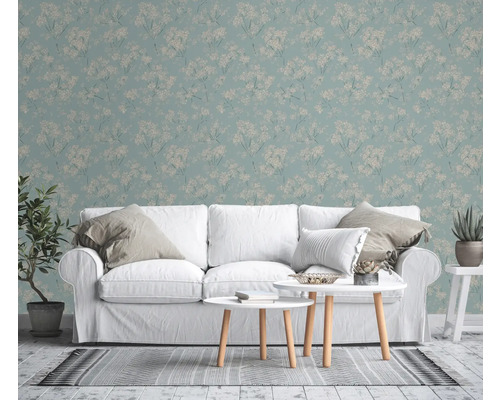 Woonkamer met bloemenbehang, witte bank en salontafels.