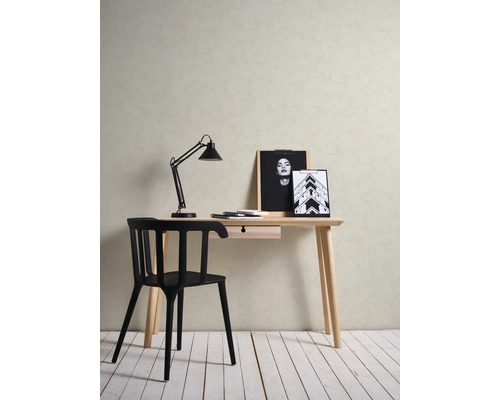 Lichte werkplek met bureau, zwarte stoel en bureaulamp en decoratieve foto''s.