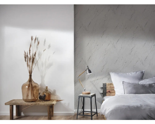 Lichte slaapkamer met patroonbehang, houten bed en decoratieve elementen op een houten tafel