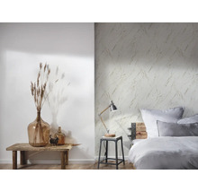 Slaapkamer met bed, lamp en een muur met marmerbehang
