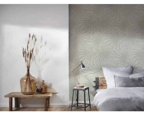 Slaapkamer met bed, tafellamp en behang met patroon