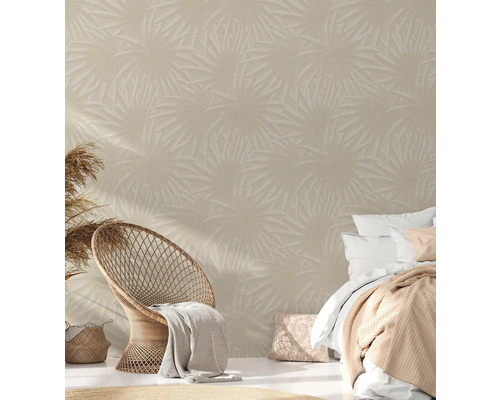 Woonkameropstelling met tropisch bladerbehang, rotan stoel en bed voor een lichte en ruime ambiance.