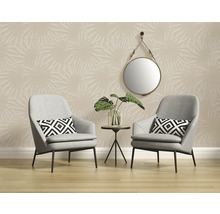 Interieur met twee grijze fauteuils, een bijzettafel met plant, een ronde spiegel en een beige behang met palmmotief