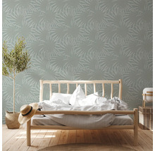 Slaapkamer met bed en behang met plantenmotief