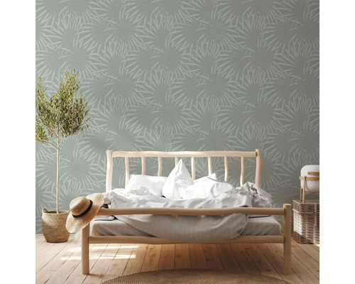 Slaapkamer met bed en behang met plantenmotief