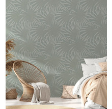 Slaapkamer met wandbehang met plantenmotief, rotan stoel en bed