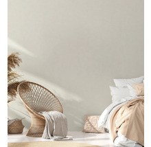 Lichte slaapkamer met rotan stoel, bed en decoratie
