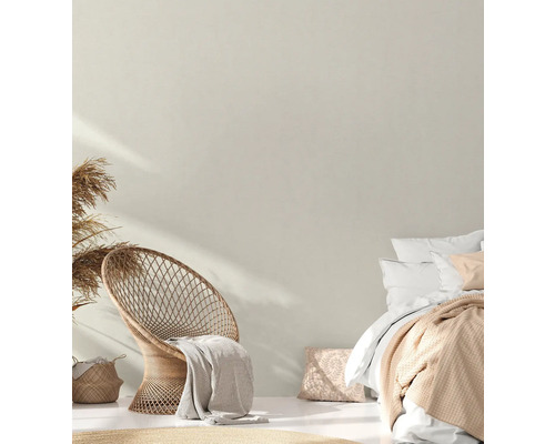 Lichte slaapkamer met rotan stoel, bed en decoratie