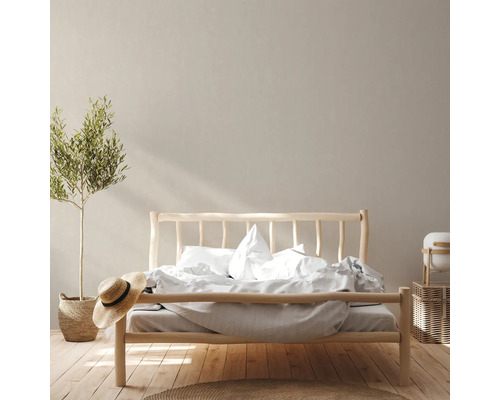 Slaapkamer met houten bed, beddengoed, kamerplant en decoratie