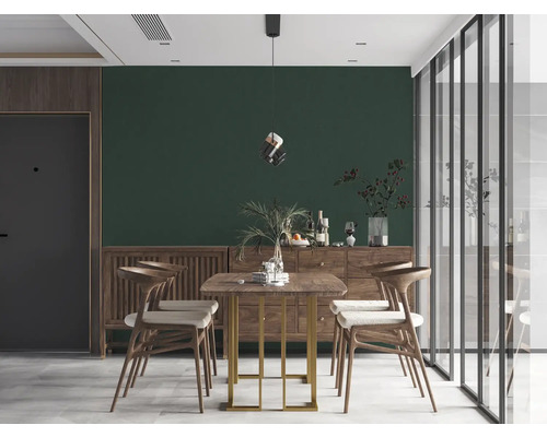 Eetkamer met houten tafel, stoelen en dressoir voor een groene muur