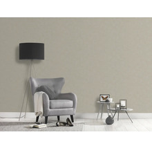 Woonkamer met beige structuurbehang, fauteuil en vloerlamp