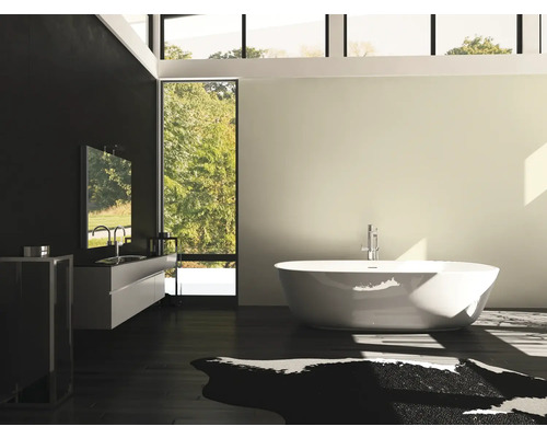 Badkamer met vrijstaand bad, wastafel en groot raam