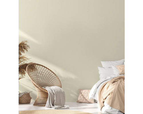 Lichte slaapkamer met rotan stoel, bed en decoratief textiel voor een gezellige sfeer