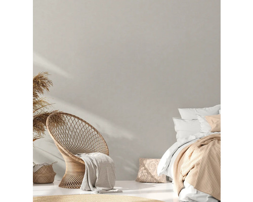 Lichte slaapkamer met rotan stoel en tweepersoonsbed