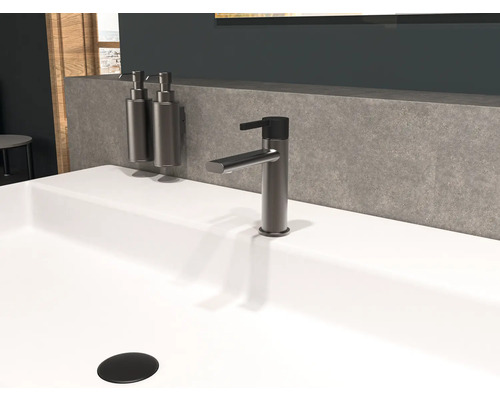 Wastafel met kraan en zeepdispenser in de badkamer