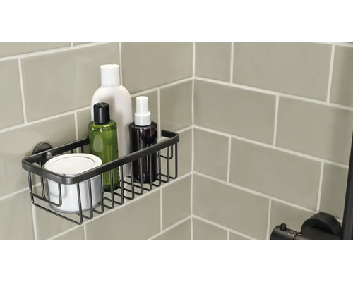 Douchebak van metaalgaas met verzorgingsproducten aan een betegelde wand