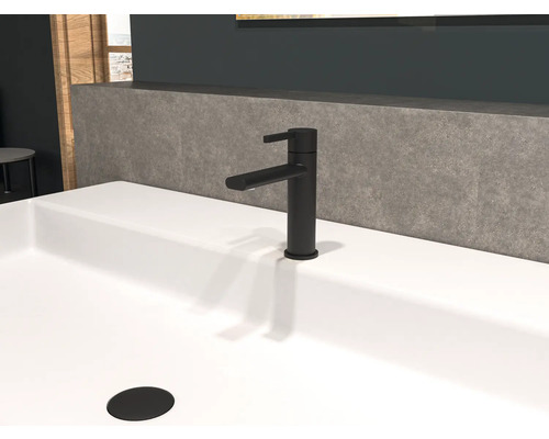 Zwarte wastafelmengkraan op een witte wasbak