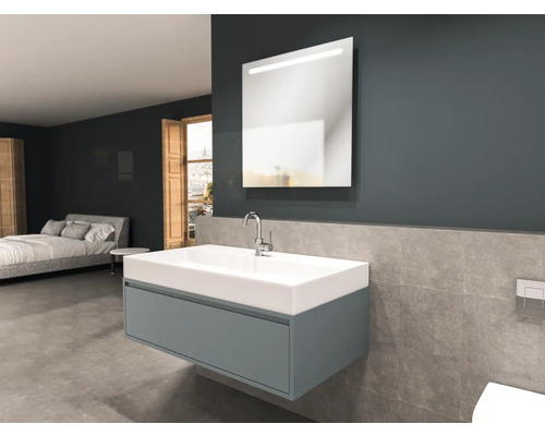 Badkamer met wastafel, spiegel en bed