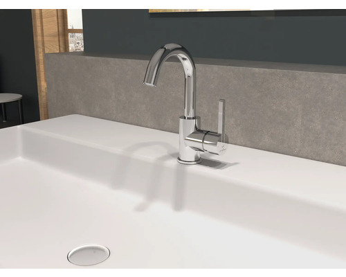 Een glimmende kraan staat op een wastafel.