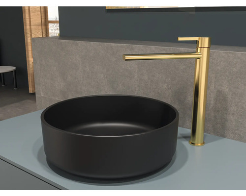 Zwarte waskom met gouden kraan op een plank