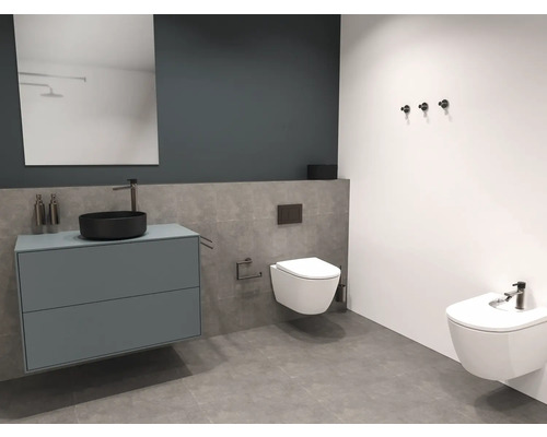 Moderne badkamer met wastafel, spiegel, toilet en bidet.