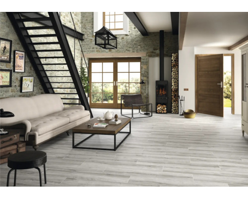 Lichte woonkamer met stenen trap, sofa, houten tafel, houtkachel en houten vloertegels met houtlook.