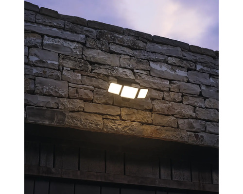 Wandlamp met drie LED-spots op een stenen muur