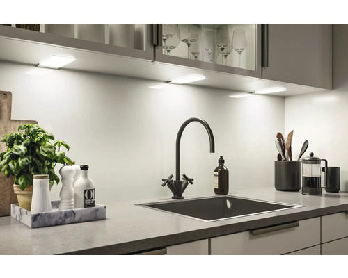 Keukenspoelbak met kraan, keukengerei en LED onderbouwlampen voor een helder werkblad