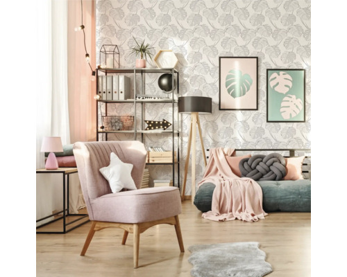 Woonkamer met fauteuil, rek en kamerplanten voor een behang met bladerpatroon