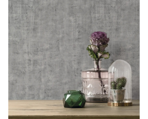 Decoratieve opstelling met vazen, plant en wandbehang op de achtergrond