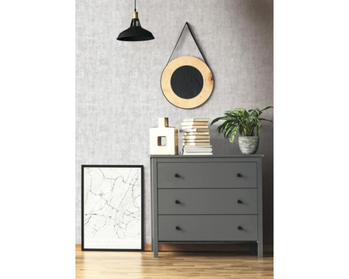 Grijze commode met drie lades in een kamer met decoratieve elementen zoals een lamp, een spiegel en een ingelijste afbeelding.