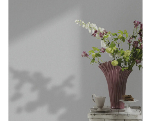 Decoratief stilleven met bloemen in een vaas, een kop en gebak op een tafel