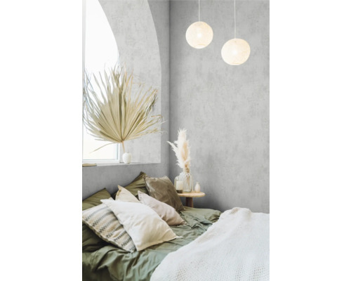 Slaapkamer met bed, kussens, lamp en decoratieve elementen voor een gezellige sfeer.