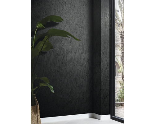 Close-up van een muur met donker structuurbehang en een kamerplant