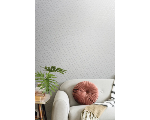 Woonkamer met patroonbehang, bank en decoratieve elementen.