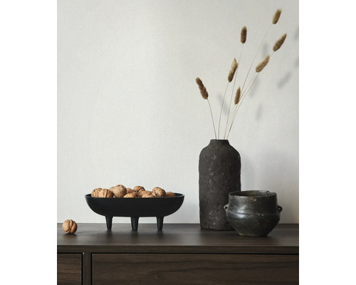 Decoratieve opstelling met een schaal op poten gevuld met walnoten, een vaas met droogbloemen en een pot.