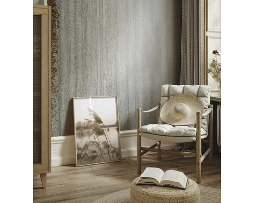 Woonkamer met gestructureerd behang, fauteuil en decoraties voor een lichte en gezellige sfeer.