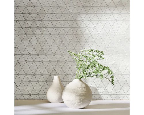 Decoratieve wandtegels met driehoekig patroon en twee vazen op een plank.